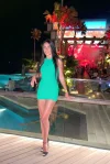 Sexy brunette lady wearing a green dress and black heels 