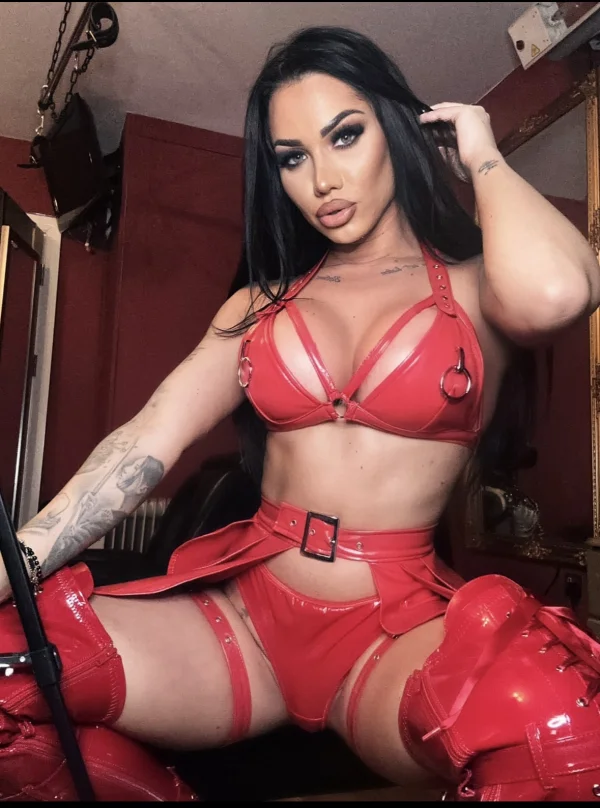A very sexy dark haired Mistress Nattasha Black is pictured in red latex underwear 